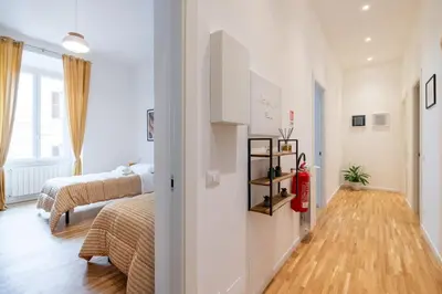 a bedroom with two beds and a wooden floor at NOSTROMONDO San Cosimato Trastevere Place in Rome