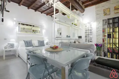 a kitchen and living room with a table and chairs at Your nest in Trastevere, the heart of Rome - Il vostro Nido nel cuore di Roma in Rome