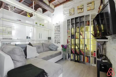 a living room with a couch and a tv at Your nest in Trastevere, the heart of Rome - Il vostro Nido nel cuore di Roma in Rome