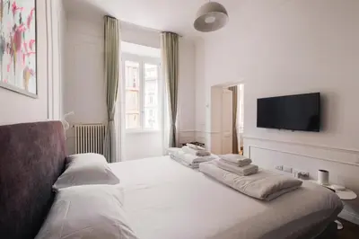 a bedroom with a white bed with a tv on the wall at Stylish 1BR, 2BATH Apartment Castel Sant'Angelo 6A in Rome