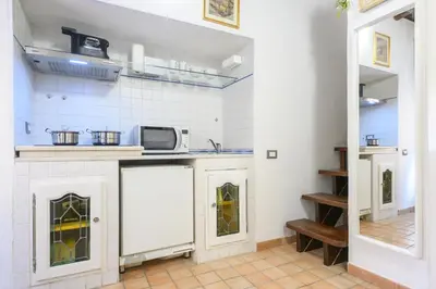 a kitchen with white cabinets and a microwave at Puccini Flat in Rome