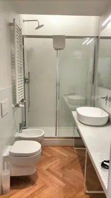 a bathroom with a toilet and two sinks and a shower at Catone 34 in Rome