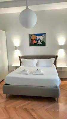 a bed in a room with two tables and two lamps at Catone 34 in Rome