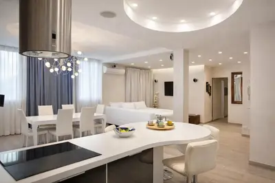 a kitchen and living room with a table and chairs at Luxury Stay in Rome Steps from Metro A Cornelia in Rome