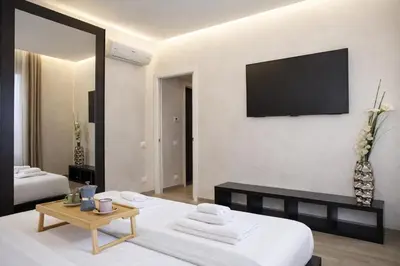 a living room with a bed and a television on a wall at Luxury Stay in Rome Steps from Metro A Cornelia in Rome