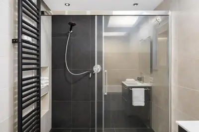 a bathroom with a shower with a glass door at Luxury Stay in Rome Steps from Metro A Cornelia in Rome