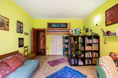 a room with a bed and a book shelf with books at Fine Art House in Rome