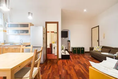 a kitchen and living room with a table and a refrigerator at Design Apartment close to Trastevere in Rome