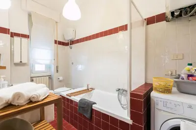 a bathroom with a tub and a washing machine at Design Apartment close to Trastevere in Rome