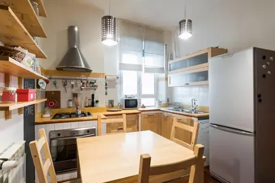 a kitchen with a wooden table and a white refrigerator at Design Apartment close to Trastevere in Rome
