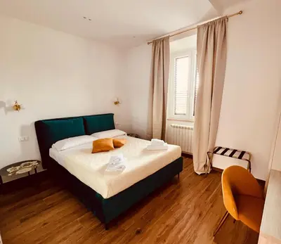 a bedroom with a bed with a green headboard at LP San Giovanni Apartment in Rome