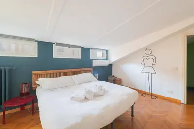 a bedroom with a white bed with a mannequin on the wall at Maison Rinascimento Roma in Rome
