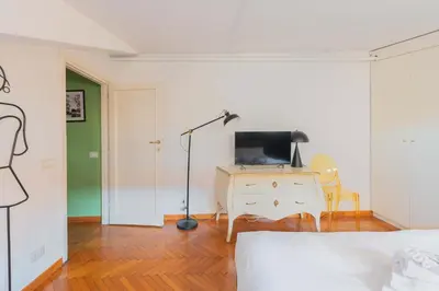 a bedroom with a bed and a desk with a television at Maison Rinascimento Roma in Rome