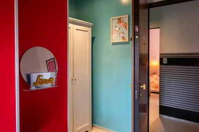 a room with a red wall and a mirror at Sanlorenzo MaDa House in Rome
