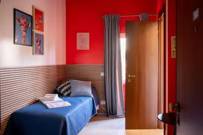 a bedroom with a blue bed and red walls at Sanlorenzo MaDa House in Rome
