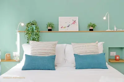 a bed with two pillows and a blue wall at Casa Magnifica in Rome