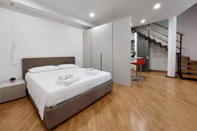 a bedroom with a large white bed and a staircase at Trevi Suite Apartment - Barberini in Rome