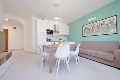 a living room with a table and chairs and a couch at Attico di Design a Garbatella con Vista San Pietro in Rome