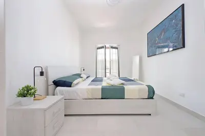 a white bedroom with a bed and a window at Attico di Design a Garbatella con Vista San Pietro in Rome