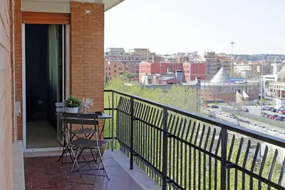 a balcony with a table and chairs and a view of a city at Attico di Design a Garbatella con Vista San Pietro in Rome
