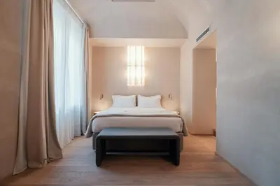 a bedroom with a bed and a stool in front of a window at Velvet Grey Boutique Hotel Roma in Rome