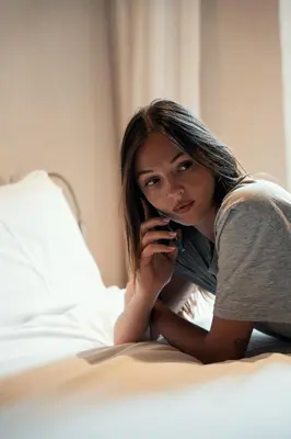 a woman laying on a bed talking on a cell phone at Velvet Grey Boutique Hotel Roma in Rome