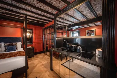 a room with red walls and a bed and a kitchen at Pantheon Suite - Residenze di Charme in Rome