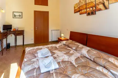 a bedroom with a bed with towels on it at MICLAD Colosseum Guest House in Rome
