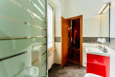 a bathroom with a sink and a toilet and a mirror at MICLAD Colosseum Guest House in Rome