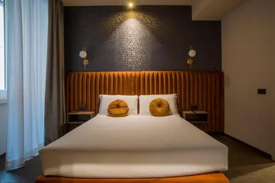 a bedroom with a large white bed with two yellow pillows at Bocca di Leone Luxury Suite in Rome