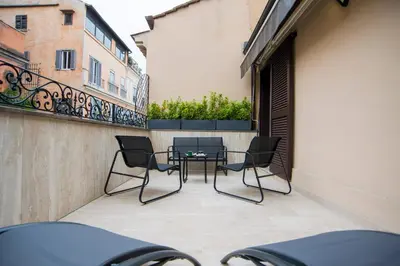 a patio with chairs and a table on a balcony at Bocca di Leone Luxury Suite in Rome