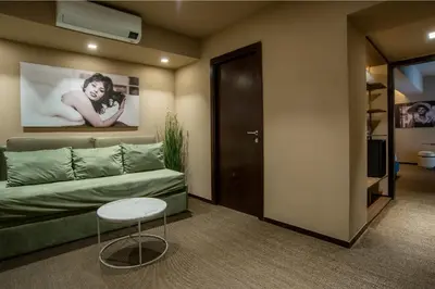 a living room with a green couch and a table at Bocca di Leone Luxury Suite in Rome