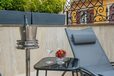 a chair and a table with a wine glass at Bocca di Leone Luxury Suite in Rome