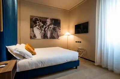a bedroom with a bed and a table and a window at Bocca di Leone Luxury Suite in Rome
