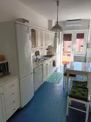a kitchen with white appliances and a blue tile floor at Casa Caselli in Rome