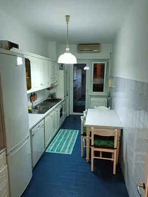 a kitchen with white cabinets and a table and a sink at Casa Caselli in Rome