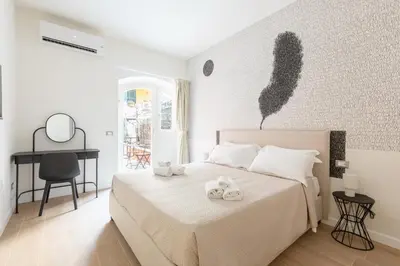 a white bedroom with a bed with towels on it at Residenza Foraggi 83 in Rome
