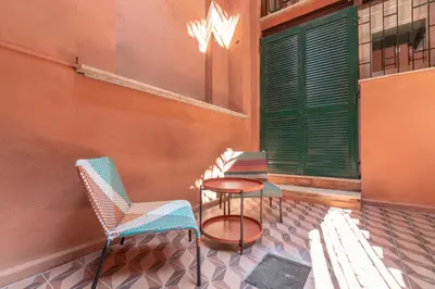 three chairs and a table on a porch with a green door at Residenza Foraggi 83 in Rome