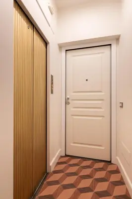 a hallway with a white door and a tiled floor at Residenza Foraggi 83 in Rome