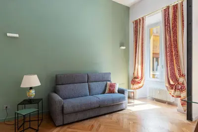 a living room with a blue couch and a window at GuestHost - Rione Prati Apartments in Rome