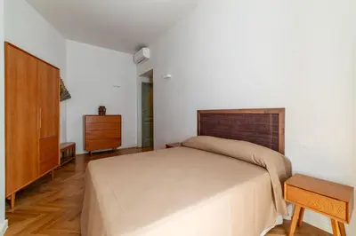 a bedroom with a large bed and a dresser at GuestHost - Rione Prati Apartments in Rome
