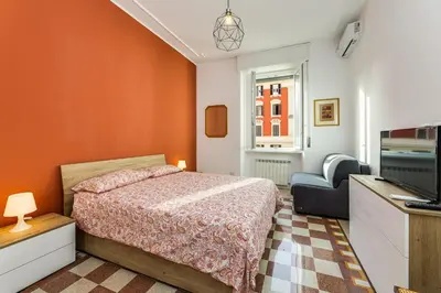 a bedroom with a bed and a tv and a chair at Giuliana Apartment Vatican in Rome