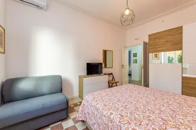 a bedroom with a bed and a chair at Giuliana Apartment Vatican in Rome