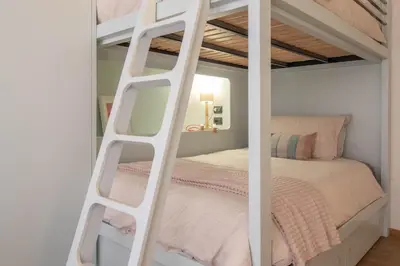 a white bunk bed with a ladder in a bedroom at Suite Color Family Roma in Rome