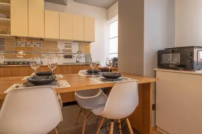 a kitchen with a wooden table with chairs and wine glasses at Suite Color Family Roma in Rome