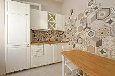 a kitchen with white cabinets and a geometric wall at Cozy new flat near the Station! in Rome