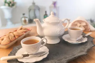 a table with two cups of tea and a tray of cookies at RomAntic Dreams Guest House in Rome