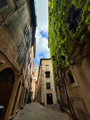 an alley between two buildings with a church in the distance at Navona Fox House 1 in Rome