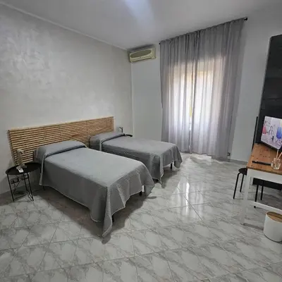 a room with two beds and a television in it at Casa Nostra a Centocelle in Rome