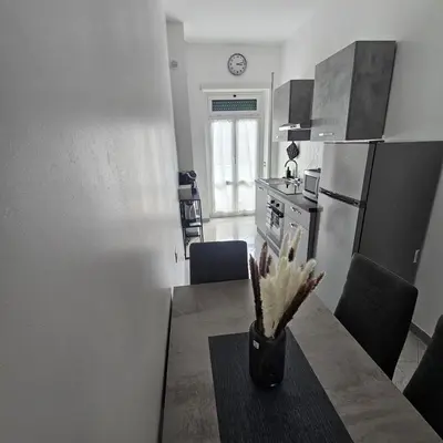 a kitchen with a table and a kitchen with a refrigerator at Casa Nostra a Centocelle in Rome